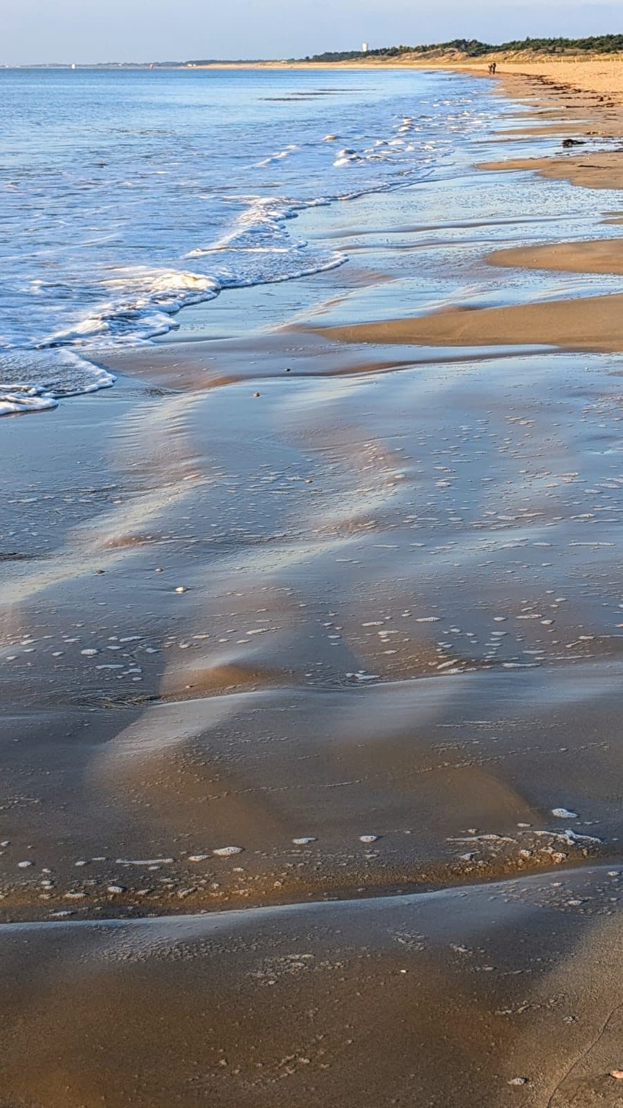 Le sable découvert ridé de filets d’eau, la marée qui remonte