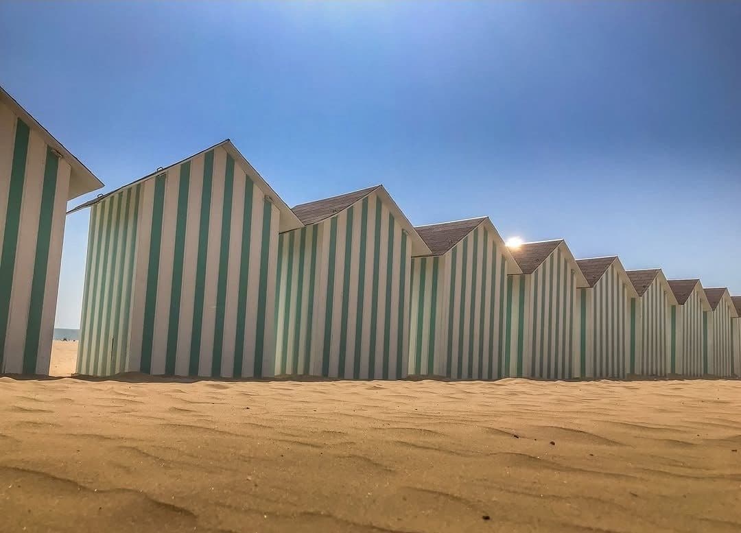 Cabines de plage rayées alignées sur le sable