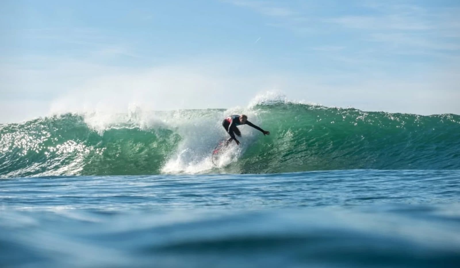 Un surfeur dans le creux d’une vague verte
